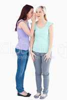 Charming woman telling friend a secret