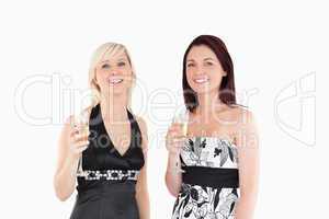 Smiling women in dresses drinking champaign