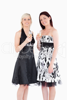 Smiling women in beautiful dresses with champaign