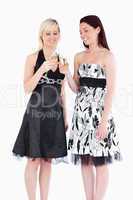 Smiling women in beautiful dresses toasting with champaign