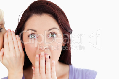 Close up of a shocked women being told a secret