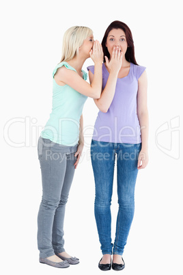 Charming woman telling her friend a secret