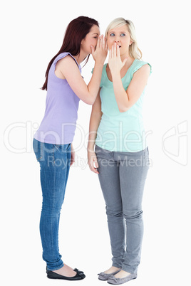 Young woman telling friend a secret