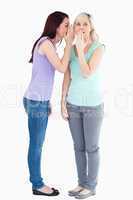 Young woman telling friend a secret