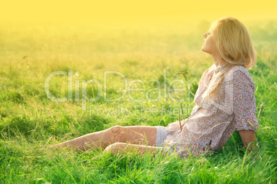 Girl is relaxing on green field