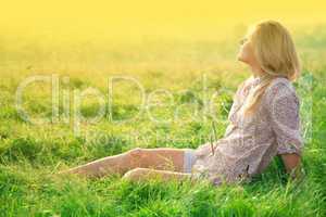 Girl is relaxing on green field