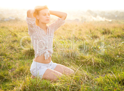 Girl is relaxing on green field