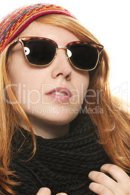 coole rothaarige frau in winterkleidung und sonnenbrille