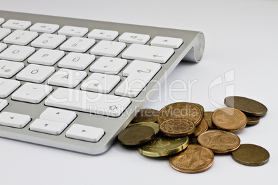 Computer keyboard with white keys and coins