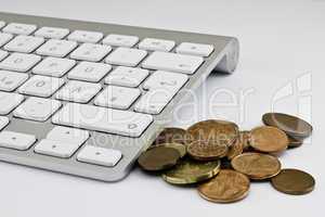 Computer keyboard with white keys and coins