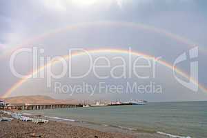 Double rainbow on sea beach