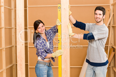 Home improvement smiling couple with spirit level