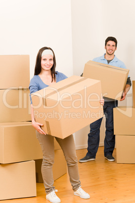 Moving home young couple carrying cardboard boxes