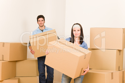 Moving home young couple carrying cardboard boxes