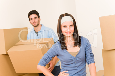 Moving home young couple carrying cardboard boxes