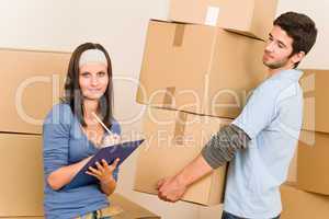 Moving home young couple carrying cardboard boxes