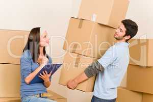 Moving home young couple carrying cardboard boxes