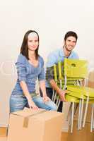 Moving new home young couple carry chairs
