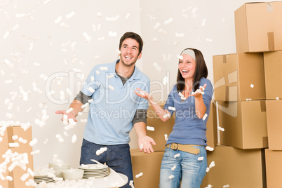 Move home cheerful couple throw Styrofoam peanuts