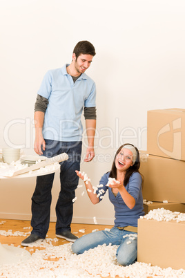 Young cheerful couple moving into new home