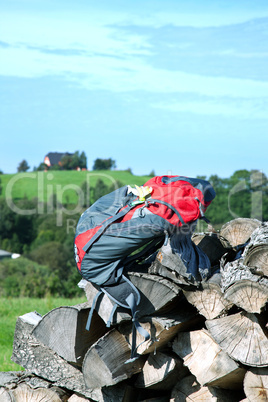 Wanderrucksack liegt auf Holzstapel