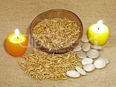 Two glowing candles and grains on wool cover.