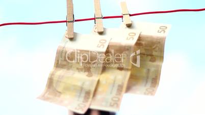 Male - removing money from a clothesline