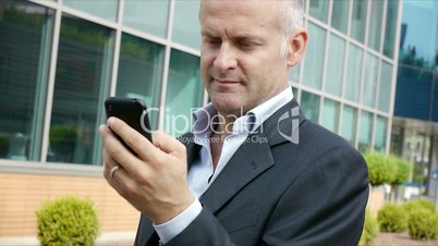 Man smiling near office building with cell phone