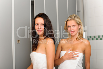 Locker room two relaxed women wrapped in towel