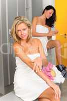 Locker room two sportive women applying lotion