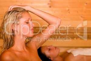 Sauna two women relaxing sweating covered towel