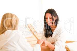 Beauty spa room two women showing manicure