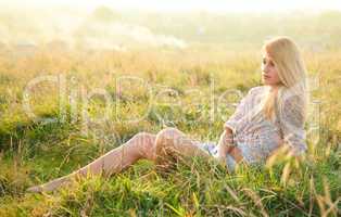 Girl is relaxing on green field