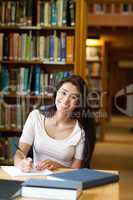 Portrait of a smiling student writing a paper