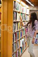 Portrait of a young woman choosing a book