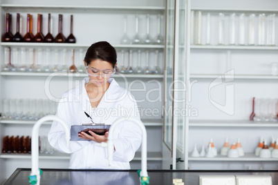 Student in science writing on a clipboard