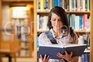 Cute young student reading a book