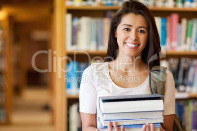 Smiling student holding books