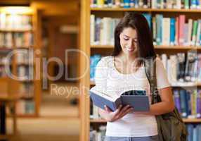 Smiling student reading a book