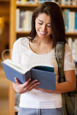 Portrait of a cute student reading a book