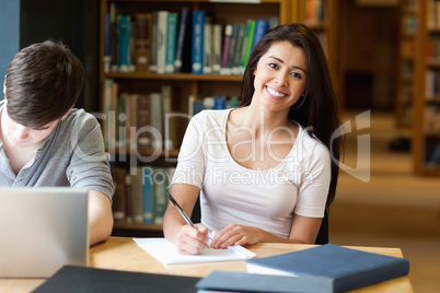 Smiling student writing a paper