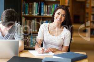 Smiling student writing a paper