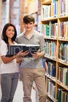 Portrait of smiling students holding a book