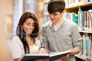 Happy students looking at a book