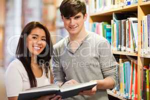 Happy students holding a book