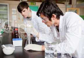Male chemistry students making an experiment