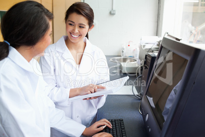 Smiling scientists working with a monitor