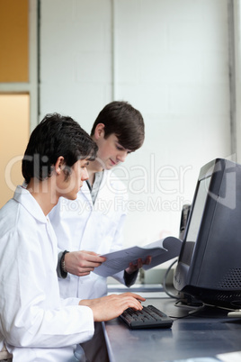 Male scientists using a monitor