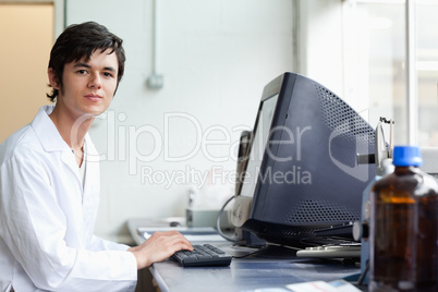 Student posing with a monitor