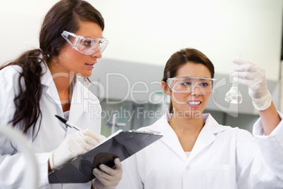 Scientist with glasses looking at a Erlenmeyer flask